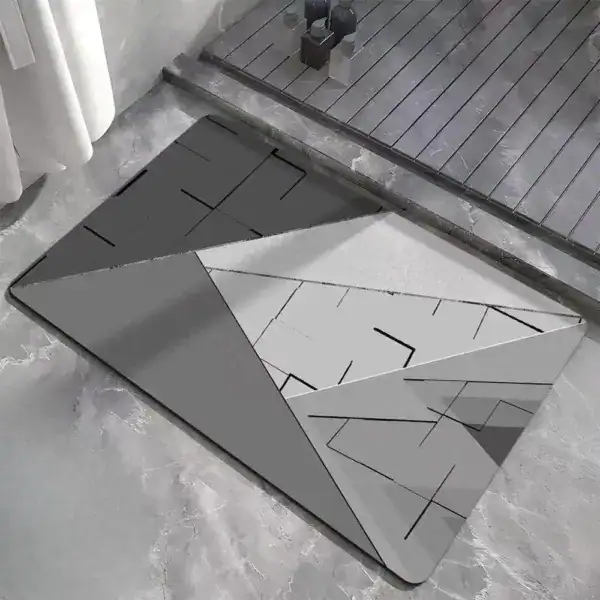 Dywanik łazienkowy w stylu geometrycznym, wzór z trójkątami i liniami, kolor szary i biały.