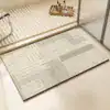 Dywanik łazienkowy w kolorze beżowym z geometrycznym wzorem w paski.